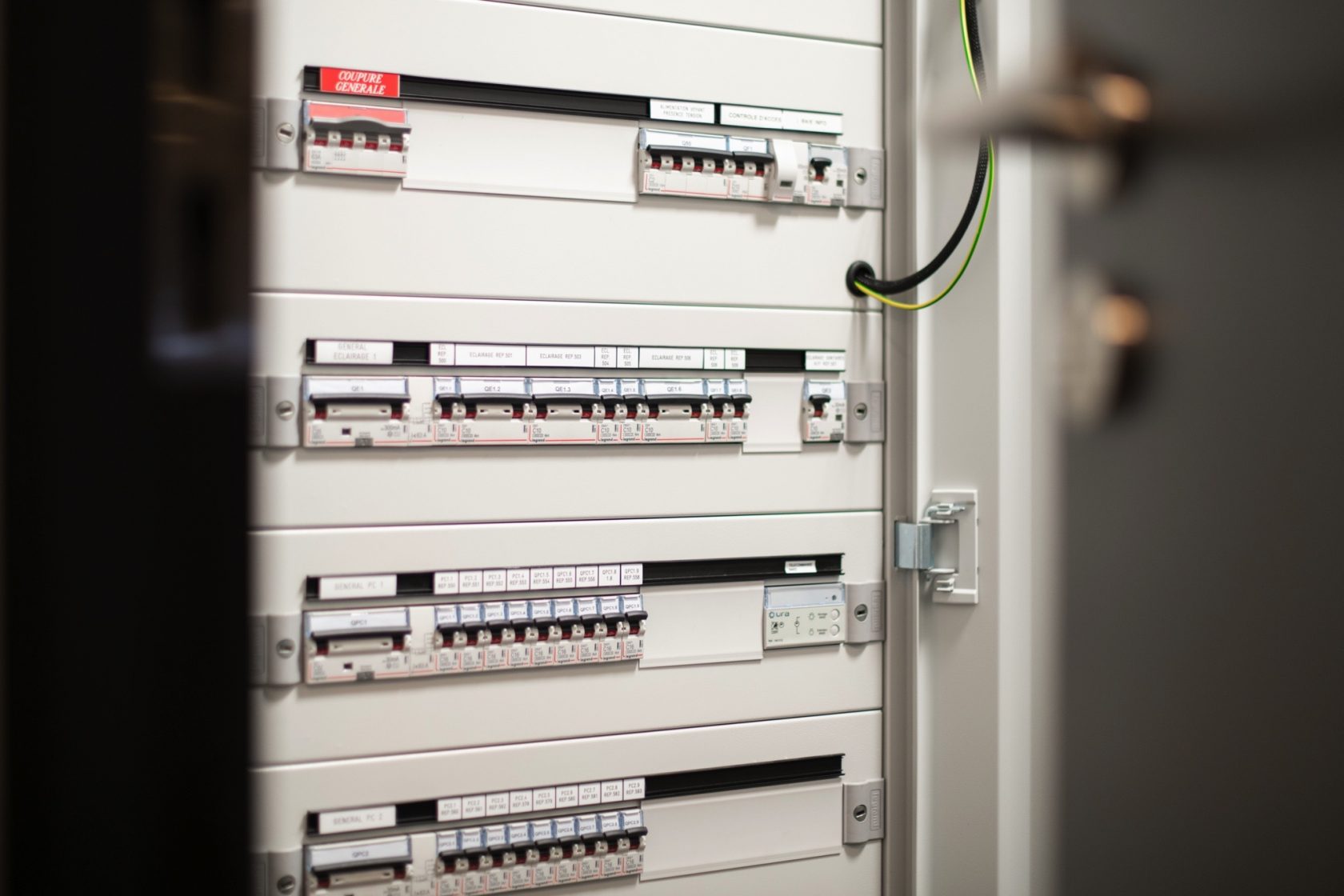 Un panneau électrique avec plusieurs disjoncteurs alignés horizontalement.