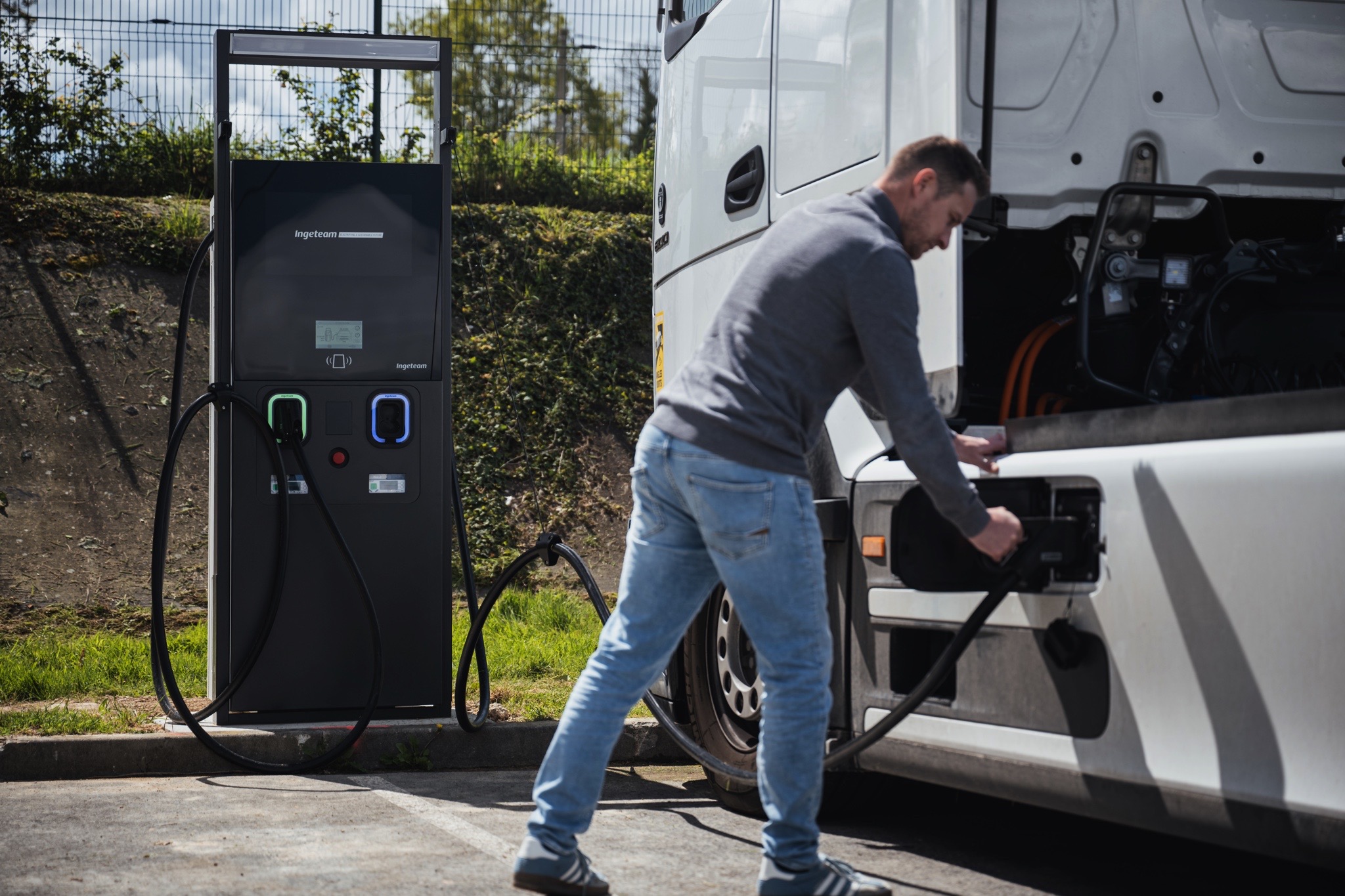 Poids lourd électrique en cours de recharge sur une borne IRVE haute puissance dans un environnement professionnel.
